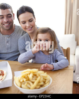 Bambina mangiare patatine fritte e la pizza a casa Foto Stock