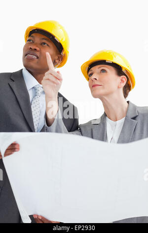 La gente di affari di indossare copricapi rigidi sono in conversazione Foto Stock