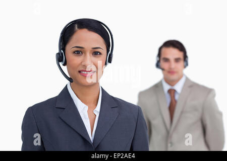 Sorridente supporto telefonico lavoratore con il collega dietro di lei Foto Stock