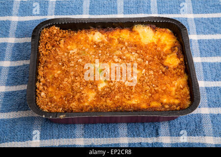 Un caldo cheesy broccoli casseruola in un tegame sul tovagliolo blu Foto Stock
