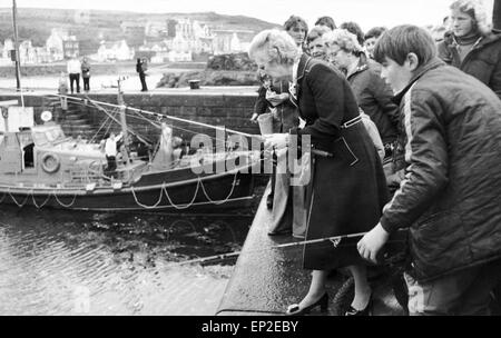 Tory leader dell opposizione Margaret Thatcher MP su 100 mile tour di Dumfries e Galloway, raffigurata la pesca a Portpatrick Harbour con Colin Paterson 13 di Jordanhill, Glasgow, Scozia, ottobre 1976. Foto Stock