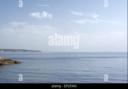 Giovane paddleboarding sul blu del mare su una soleggiata giornata di primavera il 22 aprile 2015 a Cala Estancia, Maiorca, isole Baleari, Spagna. Foto Stock