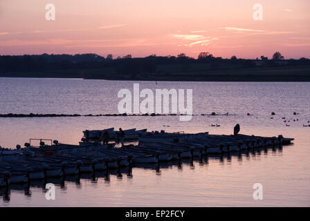 RUTLAND ACQUA, Inghilterra - Giugno 07 2013 : Fly barche da pesca silhoetted contro il Cielo di tramonto riflesso in Rutland acqua su 07 Giugno Foto Stock