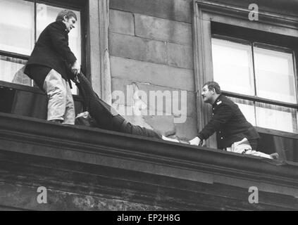 Fuoco a Maryhill Road Glasgow. Incendio in un vuoto negozio di arredamento che si propagasse lungo la fila di negozi e cattura di alcune famiglie nelle loro case di cui sopra. Cinquanta famiglie sono rimaste senza tetto ed una donna e un Fire Officer persero la vita. Sabato, 18 novembre 1972. Nella foto sono due vigili del fuoco, che hanno rischiato la loro vita su una battuta tre solai sopra St George's Cross, per trascinare un inconscio donna per la sicurezza. La donna poi recuperato. Foto Stock