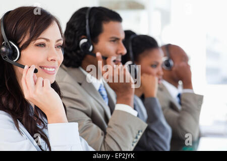 Sorridente per i dipendenti di call center lavorare mentre è accompagnato dal suo team Foto Stock