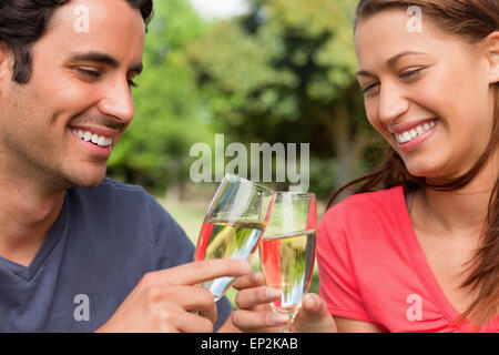 Due amici di sorridere quando toccano i bicchieri di champagne insieme in festa Foto Stock