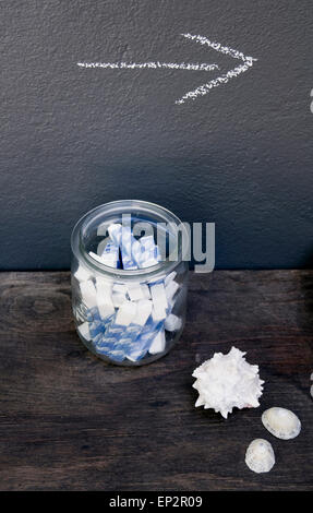 Vaso con chalk, segno di freccia, conchiglie e snailshell Foto Stock