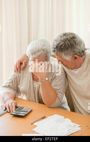 Triste Coppia matura calcolare le loro bollette domestiche Foto Stock