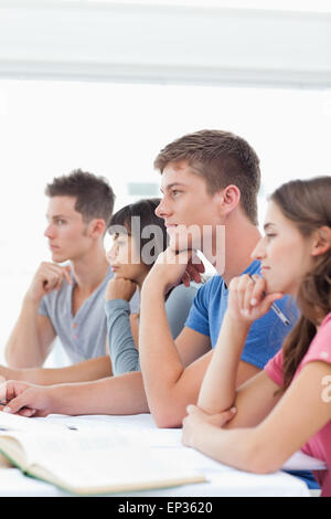 Un gruppo di studenti seduti in classe ascolto Foto Stock