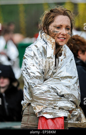 Giovane donna avvolta in emergenza coperta di salvataggio dopo aver completato la corsa a ostacoli gara Foto Stock