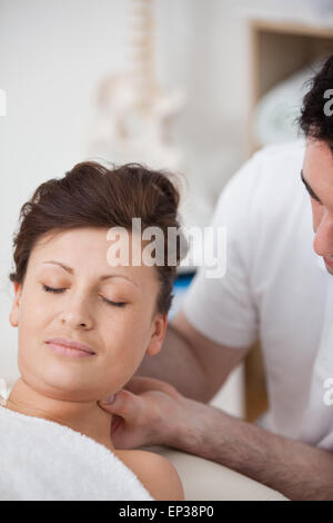 Donna essendo massaggiare la sua testa mentre si solleva Foto Stock