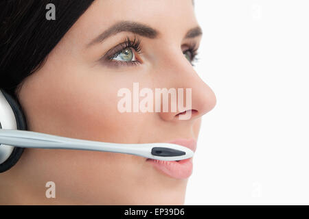 Close-up di un green eyed donna che indossa un auricolare Foto Stock