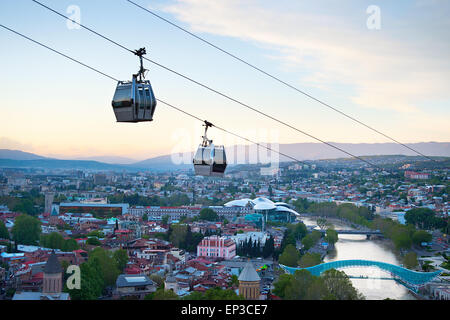 La funivia sopra la città di Tbilisi al tramonto. La Georgia Foto Stock