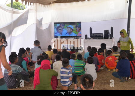 Kathmandu, Nepal. 13 Maggio, 2015. Bambini Watch TV all'interno di una tenda in quake-hit Kathmandu, Nepal, 13 maggio 2015. © Liu Chuntao/Xinhua/Alamy Live News Foto Stock