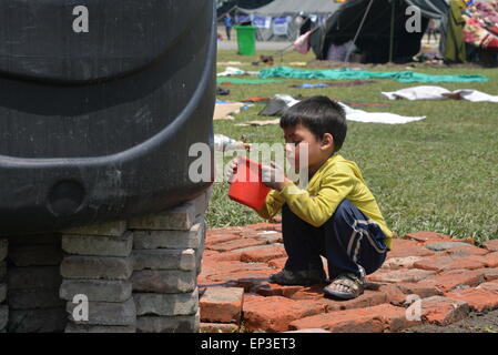 Kathmandu, Nepal. 13 Maggio, 2015. Un bambino gioca accanto a tende in quake-hit Kathmandu, Nepal, 13 maggio 2015. © Liu Chuntao/Xinhua/Alamy Live News Foto Stock