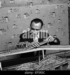 Ein Mann bastelt am Aufau einer Modelleisenbahnanlage ad Amburgo, Deutschland 1950er Jahre. Un uomo constrcuting un modello di treno com Foto Stock