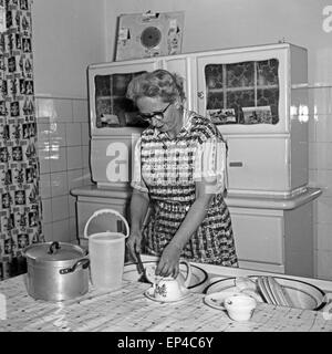 Eine Frau beim Spülen in ihrer Küche, Deutschland 1950er Jahre. Una donna facendo il lavaggio delle stoviglie nella sua cucina, Germania degli anni cinquanta. Foto Stock