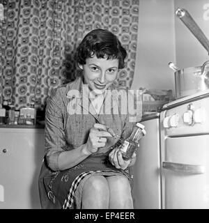 Junge Ruth Drasy sitzt in der Küche, Deutschland 1950er Jahre. Giovani Ruth Drasy seduta nella sua cucina, Germania degli anni cinquanta. Foto Stock