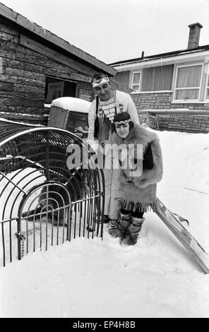 Französische Sängerin Mireille Mathieu in einem Indianerkostüm im Schnee vor einem Waschbärkäfig, Deutschland Anfang 1970er Foto Stock