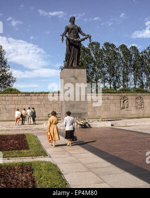 Giugno 25, 1989 - Leningrado (St. Petersburg, Russia - visitatori e turisti davanti a un enorme statua in bronzo della patria, raffigurata come una donna in lutto, da scultori V.V. Isaeva e R.Ðš. Tauritt, che troneggia sul Piskaryovskoye Memorial Cemetery di Leningrado (presente giorno San Pietroburgo) dove mezzo milione di persone, tra cui 420.000 civili e 50.000 soldati sono sepolti nel cimitero di 186 tombe di massa dopo il deterioramento durante l'epica di 900 giorni di assedio da parte dei nazisti durante la seconda guerra mondiale. (Credito Immagine: © Arnold Drapkin/ZUMA filo) Foto Stock