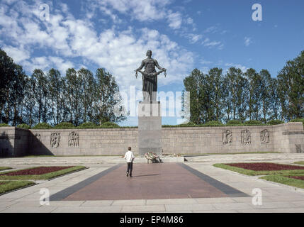 Giugno 25, 1989 - Leningrado (St. Petersburg, Russia - un giovane uomo sta davanti a un enorme statua della Madre Patria, raffigurata come una donna in lutto, da scultori V.V. Isaeva e R.Ðš. Tauritt, che troneggia sul Piskaryovskoye Memorial Cemetery di Leningrado (presente giorno San Pietroburgo) dove mezzo milione di persone, tra cui 420.000 civili e 50.000 soldati sono sepolti nel cimitero di 186 tombe di massa dopo il deterioramento durante l'epica di 900 giorni di assedio da parte dei nazisti durante la seconda guerra mondiale. (Credito Immagine: © Arnold Drapkin/ZUMA filo) Foto Stock