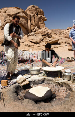 L'Egitto, il Sinai,Beduino Desert Camp, uomini rendendo fatir tradizionale o shrak pane piatto sulla pietra calda Foto Stock