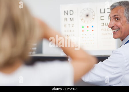 Medico di gioiosa facendo un occhio test su un paziente in un ospedale Foto Stock