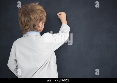 Ragazzo vestito come docente scrive sulla lavagna nera Foto Stock