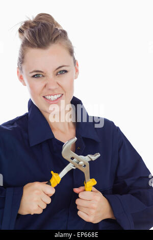 Meccanico femmina denti di aggraffaggio tenendo la pinza chiave Foto Stock