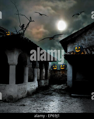 Zucche di Halloween nel cortile di una vecchia casa di sera al chiaro di luna Foto Stock