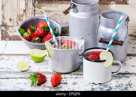 Vintage tazze in metallo con retro cocktail di tubi e acqua-lattine di fragole fatta in casa la limonata, servita con fragole fresche, min Foto Stock