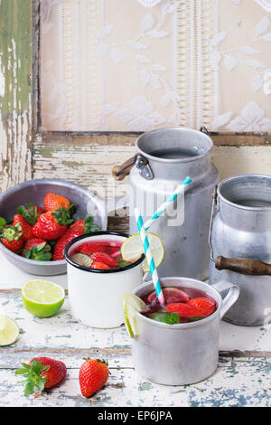 Vintage tazze in metallo con retro cocktail di tubi e acqua-lattine di fragole fatta in casa la limonata, servita con fragole fresche, min Foto Stock