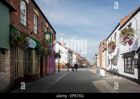 I pedoni e i fiori in mostra in Northload Street, Glastonbury Foto Stock