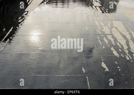 Luce e ombra che riflette l'acqua che scorre sulla pavimentazione di pietra, REGNO UNITO Foto Stock