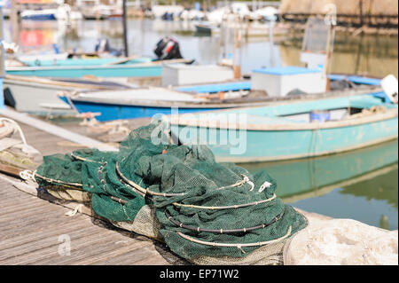 Le reti da pesca in banchina, in background le barche da pesca Foto Stock