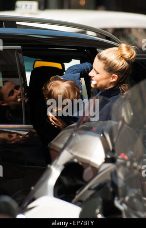 Michelle Hunziker tiene in bocca onu lecca lecca da osare alla figlioletta suola, mentre la tira fuori dall'auto Foto Stock