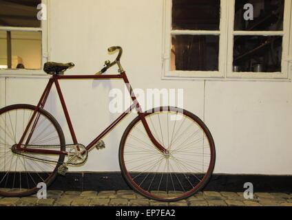 Unico vecchia bicicletta semplice appoggiata sul muro bianco Foto Stock