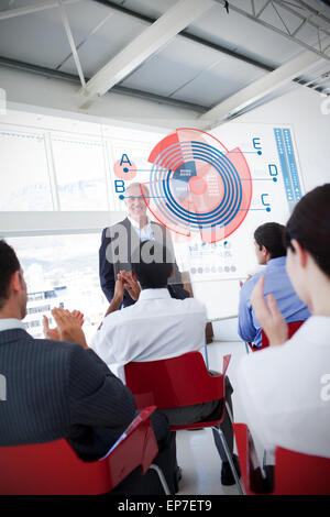 La gente di affari battimani stakeholder in piedi di fronte ad interfaccia schema Foto Stock