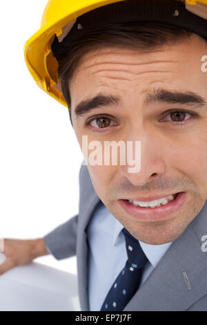 Close up di architetto smorfie mentre i piani di contenimento Foto Stock