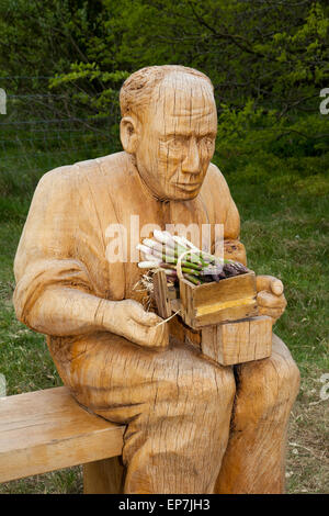 Formby, Southport, Merseyside Regno Unito 14 maggio, 2015. Carbed famiglia in legno statua del padre del signor David Brooks di Formby asparagi. Larkhill Farm è la terza generazione di Brook famiglia di agricoltori locali che hanno aree livellato di dune e lavorato questi terreni sabbiosi sul Formby costa a far crescere gli asparagi, una prelibatezza locale che può ancora essere goduto in breve stagione tra i primi di maggio e il 21 giugno. Il National Trust ha recentemente eretto statue intagliate lungo il nuovo sentiero per contrassegnare la coltivazione tradizionale della canapa, in suoli sabbiosi e con un clima favorevole riscaldata dal mare Foto Stock