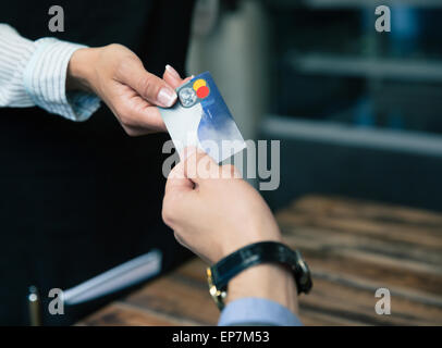 Primo piano immagine di un uomo di pagare con carta di credito presso il ristorante Foto Stock