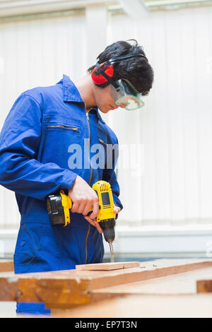 Studente di una classe di macchine per la lavorazione del legno di una foratura Foto Stock