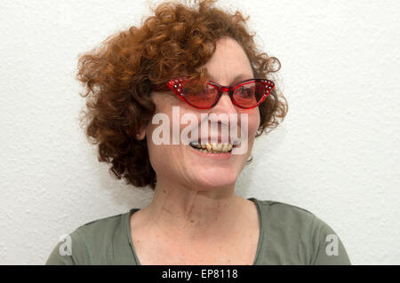 Donna tedesca indossando colorati di rosso occhiali da sole Foto Stock