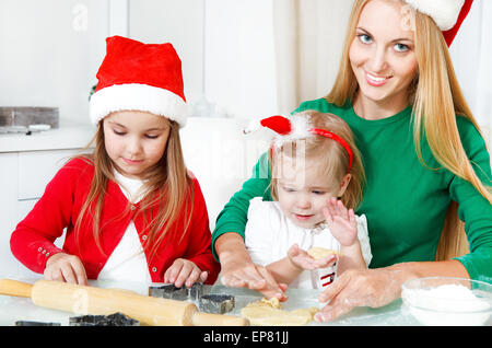 Adorabili ragazze con sua madre la cottura biscotti di Natale in cucina Foto Stock