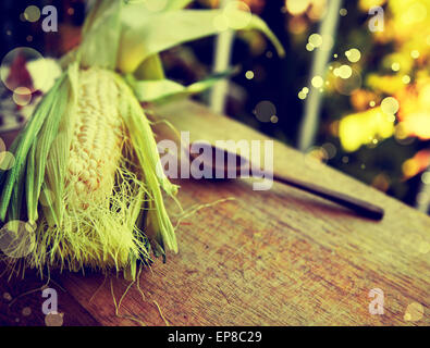 Orecchio di mais, il cucchiaio di legno sul vecchio tavolo in legno, alimentari sfondo, tema di caduta Foto Stock