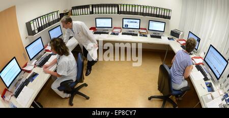 Leipzig, Germania. 24 apr, 2015. Gli infermieri Sabine (L) e Christine, e capo medico Thomas Koehnlein monitorare pazienti sul monitor in laboratorio del sonno di Robert Koch clinica di Leipzig, Germania, 24 aprile 2015. In otto camere singole, i pazienti vengono agganciate e videoregistrate per monitorare le onde cerebrali, il respiro, il ritmo cardiaco e tutti i movimenti durante il sonno. Foto: Waltraud Grubitzsch/dpa/Alamy Live News Foto Stock