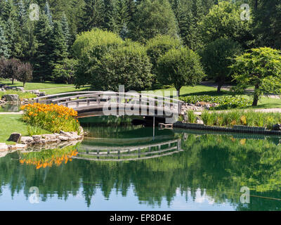 Ponte su acque calme nel giardino giapponese. Un ponte di ornamentali in Kurimoto giardino giapponese Foto Stock