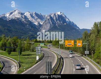 La strada federale B2 all'uscita dal tunnel di Farchant e ingresso del paese di Garmisch-Partenkirchen, montagne del Wetterstein con Foto Stock