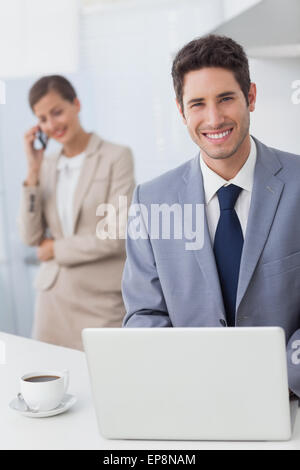 Happy businessman usando un computer portatile prima di andare al lavoro Foto Stock