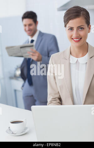 Imprenditrice usando un computer portatile prima di andare al lavoro Foto Stock